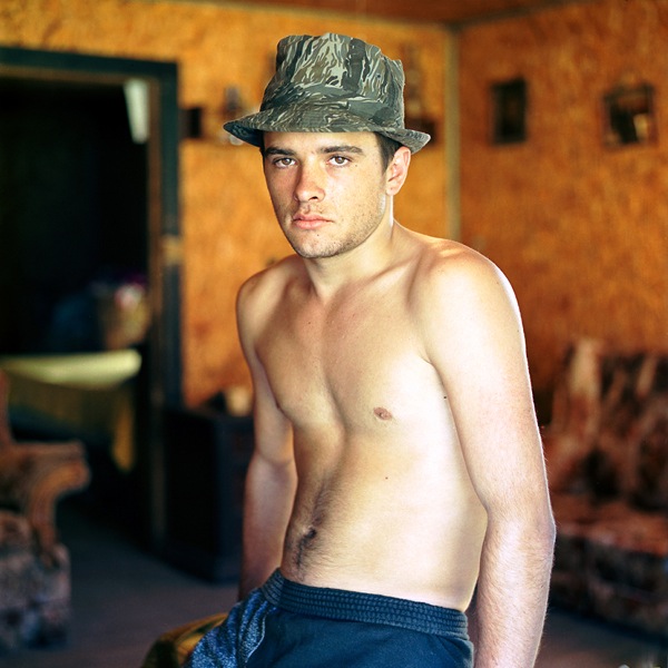 Young Man with Hat seated indoors